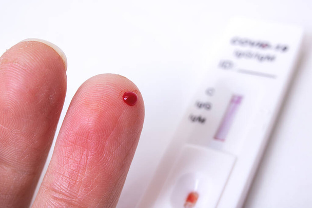 Bir damla kan ve koronavirüs testiyle delinmiş parmak yakından incelensin. - Fotoğraf, Görsel