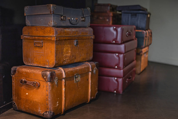 Pile of vintage, warn travel suitcases or trunks on the floor - Foto, imagen