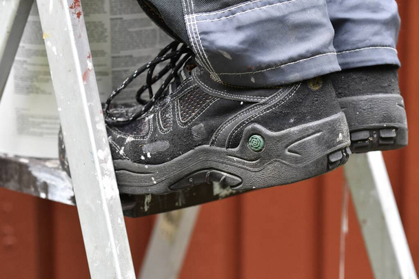 Primer plano de los zapatos del pintor o trabajador que realiza la renovación o mejora del hogar - Foto, Imagen