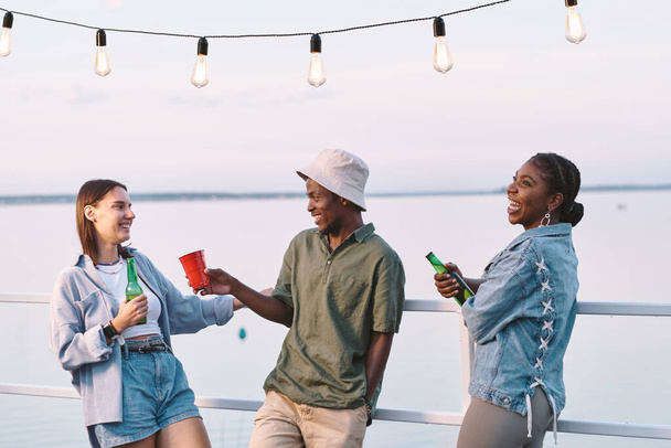 Grupo de jóvenes amigos multirraciales con bebidas divirtiéndose - Foto, imagen