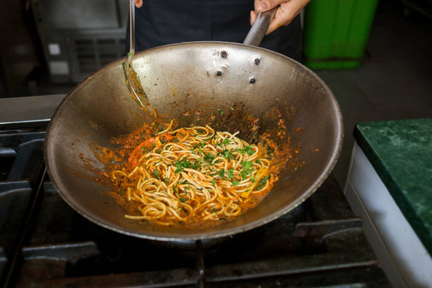 foto de espaguetis con salsa en un wok - Foto, Imagen
