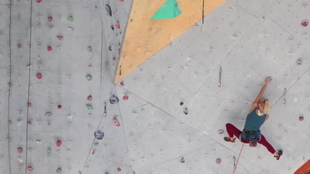 Kalliokiipeilijä kiipeää reittiä. kiipeilyseinä kaupungin extreme urheilu. - Materiaali, video