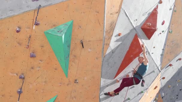 alpinista wspina się na trasę. ściana wspinaczkowa w mieście dla sportów ekstremalnych. - Materiał filmowy, wideo