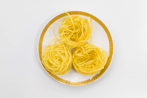 Raw pasta in a plate. Abstract culinary background with copy space for text. - 写真・画像