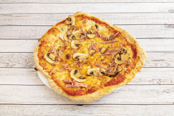 Italian mushroom pizza with cooked ham and oregano with olive oil and fried tomato - Photo, image