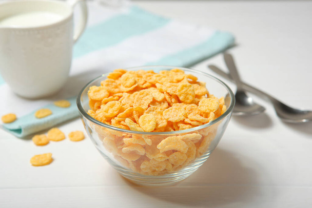  Knusprige Cornflakes mit Milch zum Frühstück aus nächster Nähe auf dem Tisch. - Foto, Bild