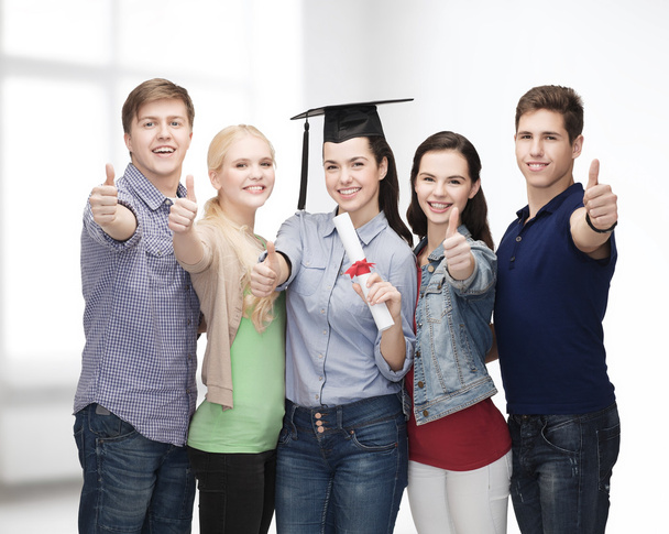 Grupo de estudiantes con diploma mostrando pulgares hacia arriba
 - Foto, Imagen