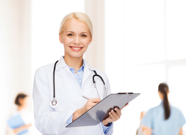 smiling female doctor with clipboard - Photo, Image