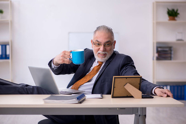 Alte männliche Angestellte trinkt Kaffee in der Pause - Foto, Bild