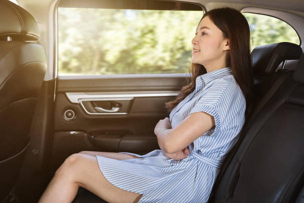 young woman sitting at the back seat of car - Foto, immagini