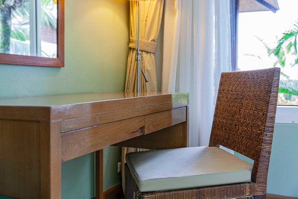 ブラウン籐製の椅子と木製の化粧台で現代の寝室 - 写真・画像