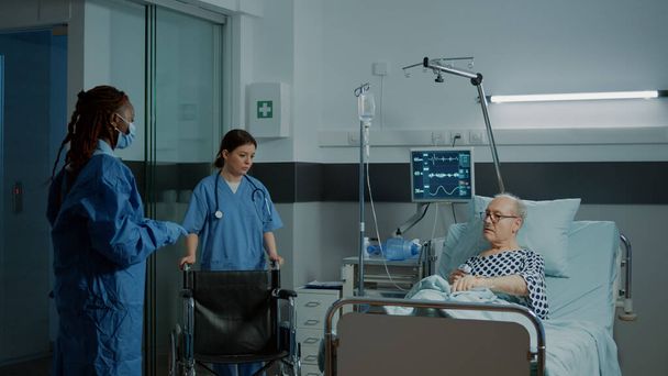 Ασθενής που κάθεται σε αναπηρικό καροτσάκι σε νοσοκομειακό θάλαμο στην κλινική - Φωτογραφία, εικόνα