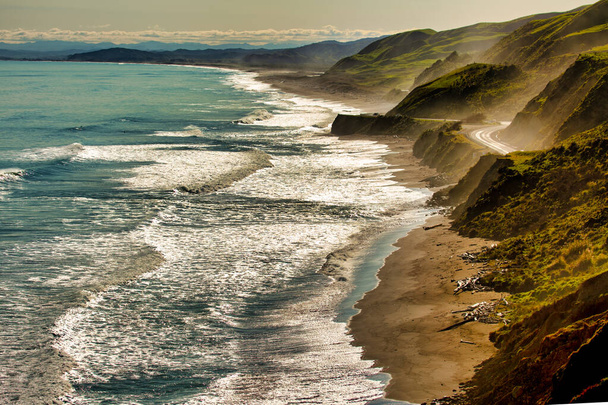 The ocean spray from the crashing waves hitting the coastal road and seaside cliffs off the Gisborne Coast - Photo, Image
