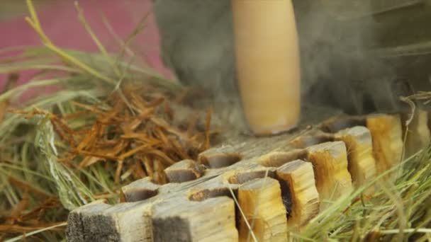 Taladro hecho a mano en el tablero de fuego o el zócalo para crear fuego
 - Metraje, vídeo