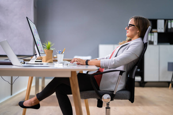 Woman Sitting In Bad Posture Working On Computer In Office - Foto, Imagem