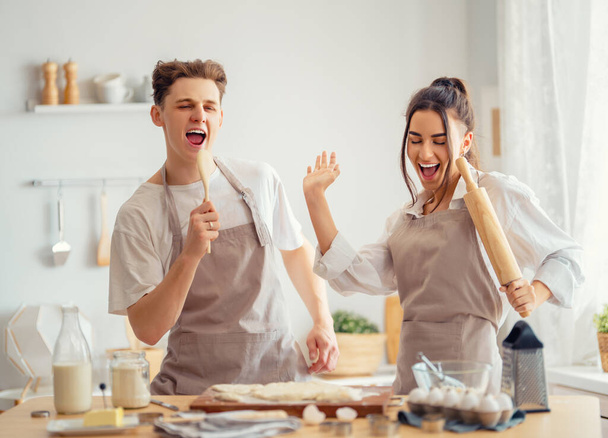 Happy loving couple is preparing the pastry in the kitchen. - Zdjęcie, obraz