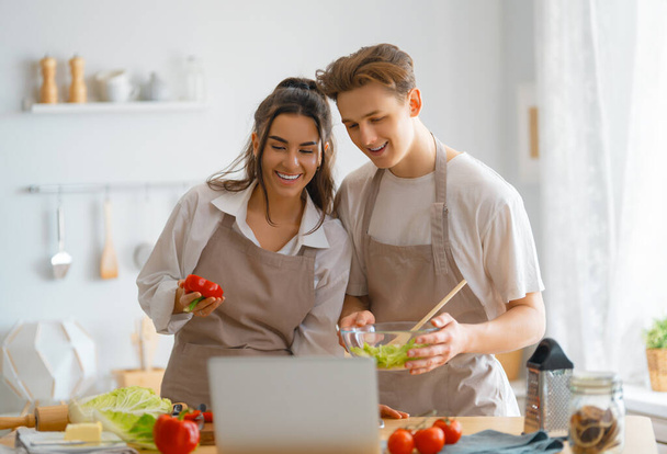 Healthy food at home. Happy loving couple is preparing the proper meal in the kitchen. - Foto, imagen