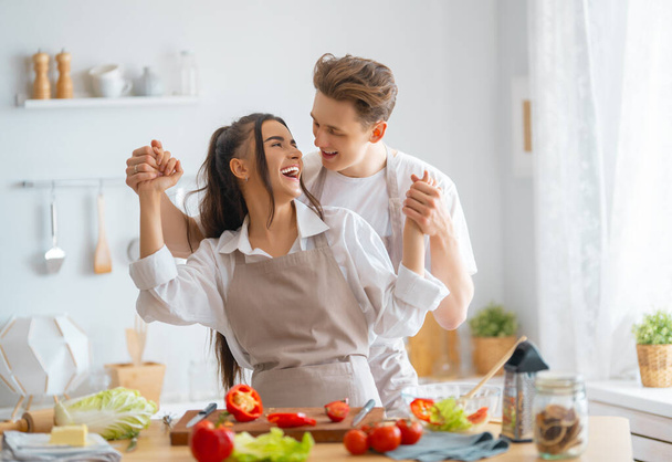Healthy food at home. Happy loving couple is preparing the proper meal in the kitchen. - Foto, Bild
