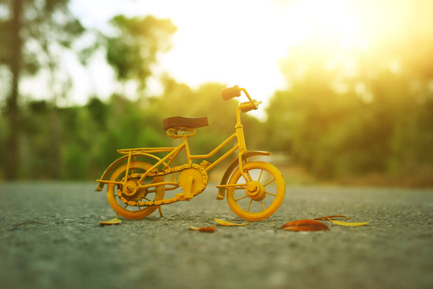 Синя старовинна велосипедна іграшка чекає на відкритому повітрі під час заходу сонця
 - Фото, зображення