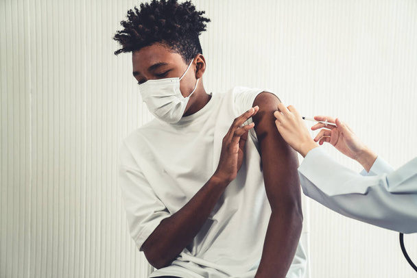 Молодой человек посещает опытного врача в больнице для вакцинации - Фото, изображение