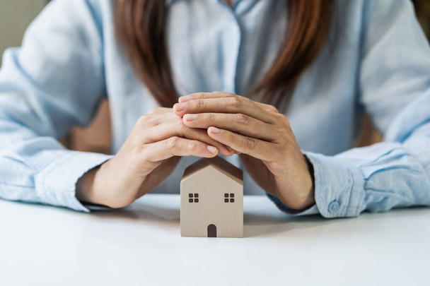 Young woman hands protecting miniature house, Home insurance concept - Photo, Image
