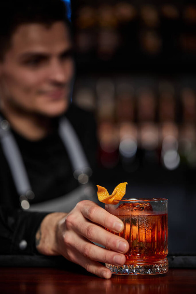 Barman holding out glass with alcoholic cocktail - Foto, Imagem