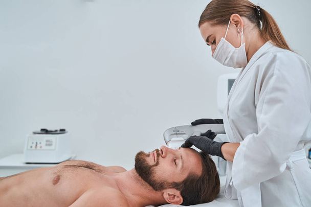 Dermatologue féminine effectuant le resserrement non chirurgical de la peau par ultrasons - Photo, image