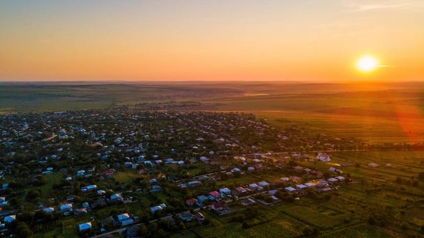 Drohnenaufnahme eines Dorfes in Moldawien bei Sonnenuntergang. Weite Felder drumherum - Foto, Bild