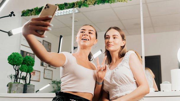 Dwie szczęśliwe kobiety robią sobie selfie w salonie piękności - Zdjęcie, obraz