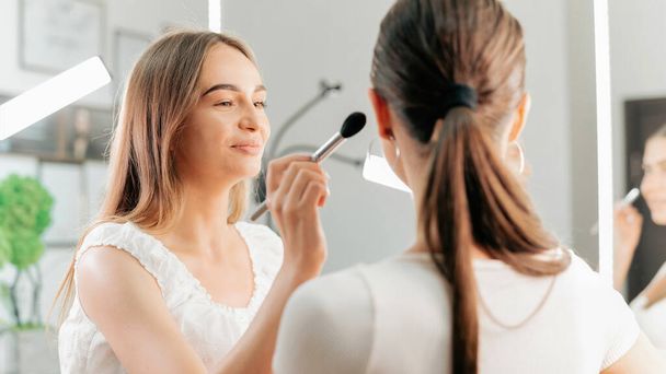 Sorridente make-up master fa il trucco per un cliente. Pittura della pelle - Foto, immagini