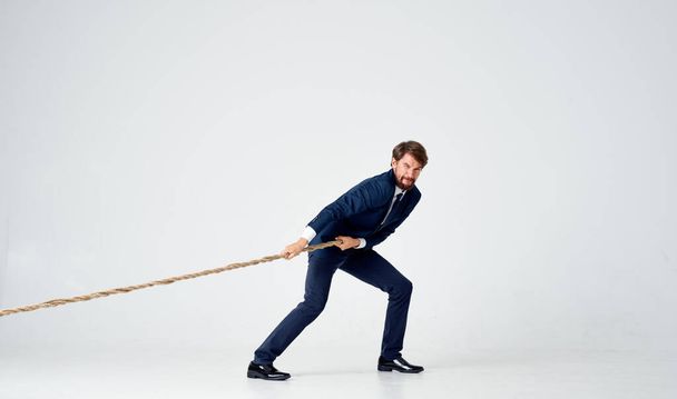 hombre de negocios en un traje tira de la cuerda emociones estudio - Foto, Imagen