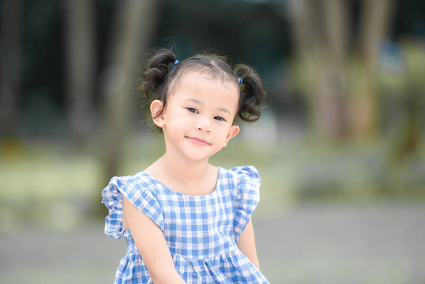 Asiática niña feliz en el parque jardín árbol fondo, hermoso niño divertirse jugando al aire libre con sonrisa feliz niños jugando al aire libre niña retrato. - Foto, imagen