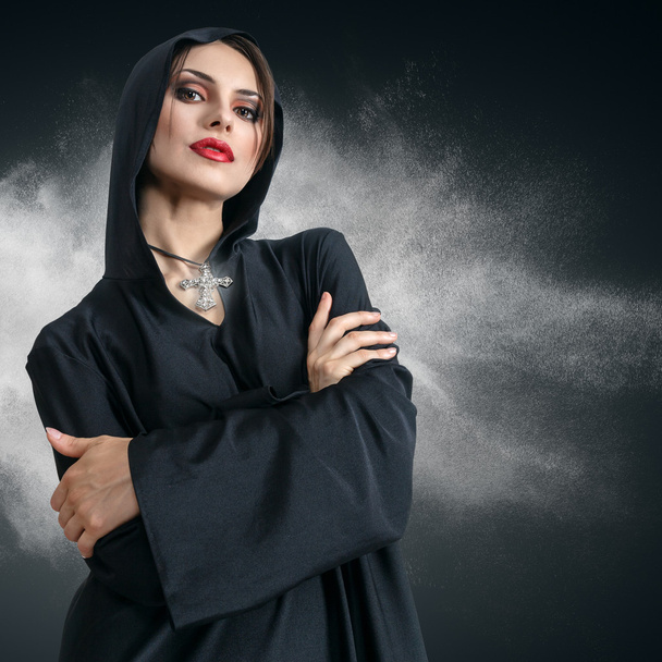 Young woman in black hood with cross - Foto, Bild