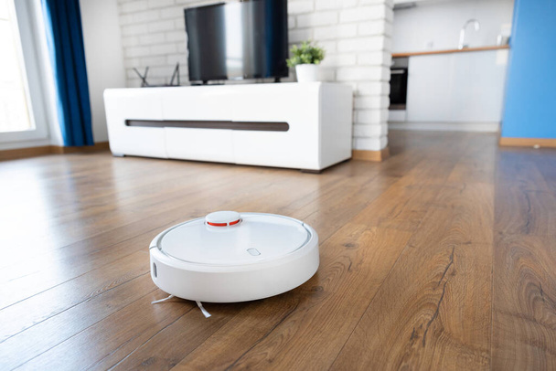 Robotic vacuum cleaner cleaning the room. Smart home concept - Zdjęcie, obraz