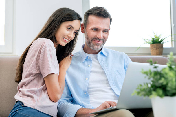 Couple using laptop, watching movie, browsing internet. Happy couple. - Фото, изображение
