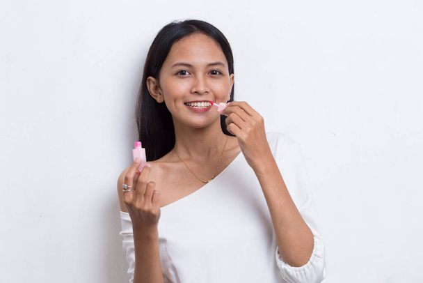 belle jeune asiatique femme en utilisant rouge à lèvres isolé sur fond blanc - Photo, image