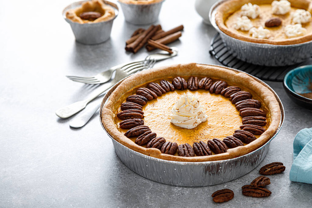 Pumpkin pie with cinnamon, pecan nuts and whipped cream for Thanksgiving. - Φωτογραφία, εικόνα