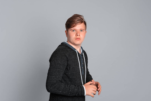 Stunned teen boy stares at camera, looks surprisingly, dumbstruck shocked gasping, realizes bad news, stands on grey background. Wow, omg male face - Fotoğraf, Görsel