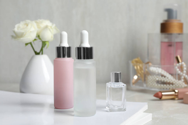 Bottles of cosmetic products on light grey table - Valokuva, kuva