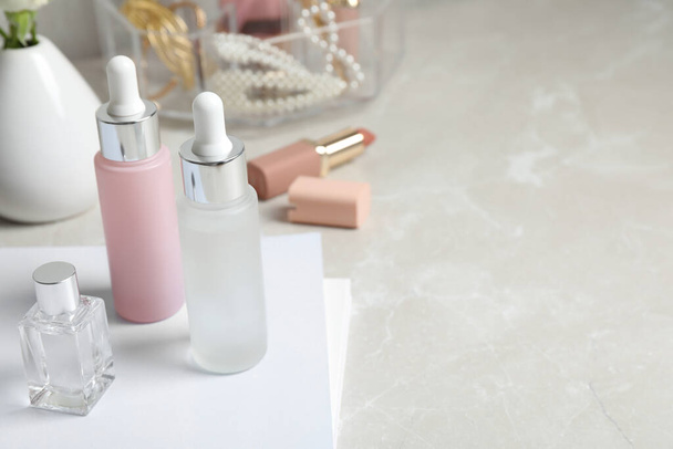Bottles of cosmetic products on light grey table, space for text - Photo, Image