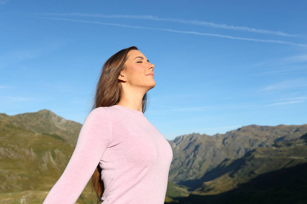Casual woman breathing fresh air in a high mountain a sunny day - Foto, imagen