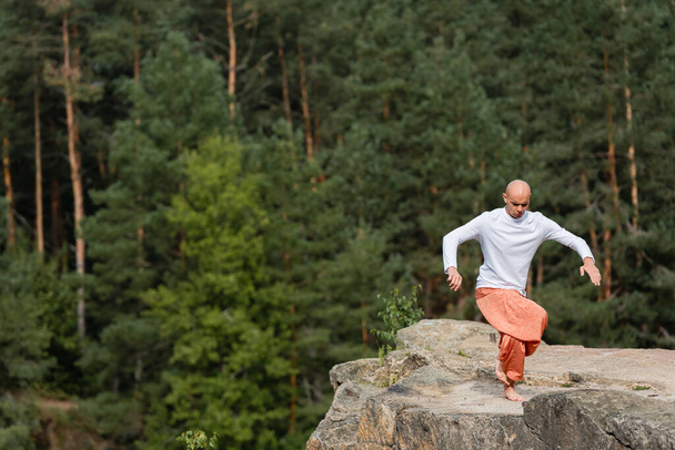 paljain jaloin buddhalainen meditointi joogassa aiheuttaa kalliojyrkänteellä metsässä - Valokuva, kuva