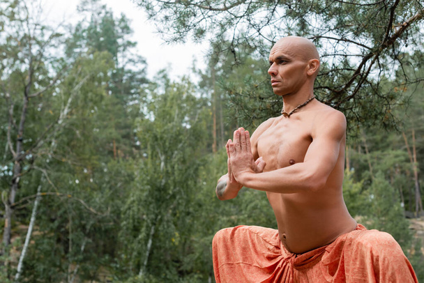 без рубашки буддист медитирует в позе йоги с молитвенными руками на открытом воздухе - Фото, изображение