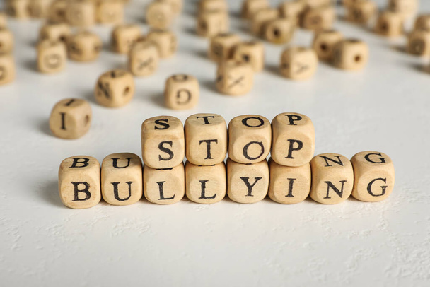 Phrase Stop Bullying made of wooden cubes with letters on stone surface, closeup - Φωτογραφία, εικόνα