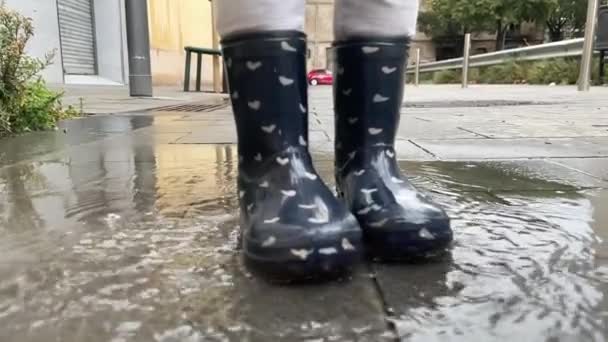 słodkie mała dziewczyna skoków w deszcz kałuża - Materiał filmowy, wideo