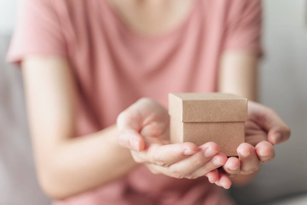 Закрыть женские руки с маленькой подарочной коробкой. Маленькая коробочка подарков в руках женщины - Фото, изображение