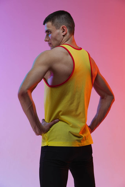 Back view portrait of young male professional athlete isolated over gradient studio background - Foto, afbeelding
