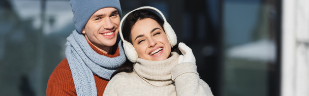счастливая молодая пара в зимнем наряде, улыбающаяся на улице, баннер - Фото, изображение