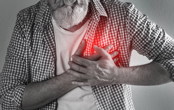 Mature man having heart attack on light background, closeup - Фото, изображение