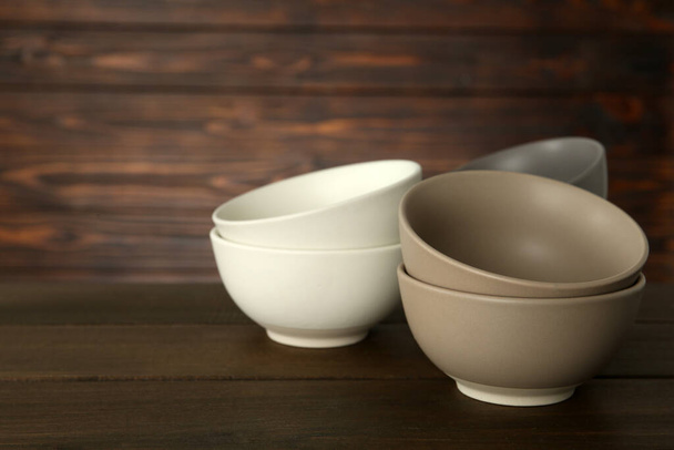 Stylish empty ceramic bowls on wooden table, space for text. Cooking utensils - Foto, Imagem